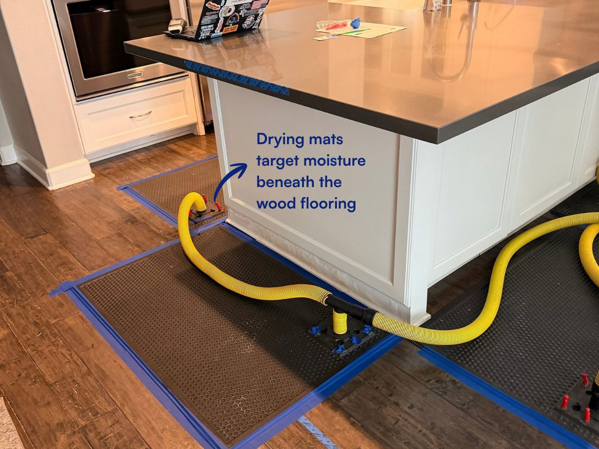 Drying mats and hoses on the wood floor around the island, drawing moisture out from beneath the flooring.
